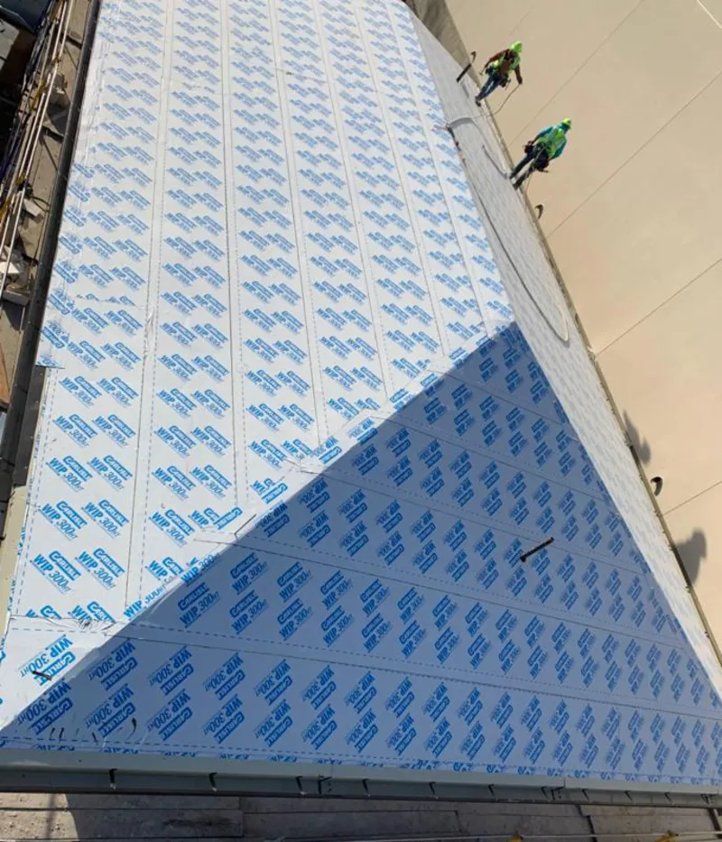 Professional roofers installing underlayment on a metal roof in Oak Bluffs